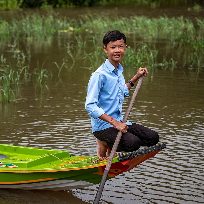 In Cambodia, a boy sits in the boat that he uses to get to his floating school