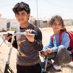 Young brothers take a break from a bicycle ride around the refugee camp where they live in Jordan.