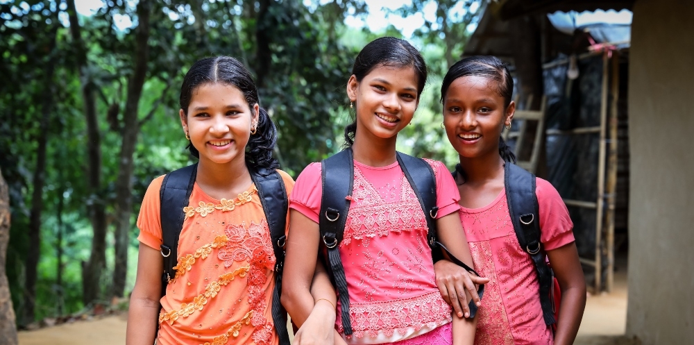 Three girls with school bags