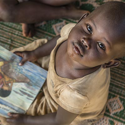 A child at a reading workshop run by Save the Children at Mahama Refugee Camp, Rwanda