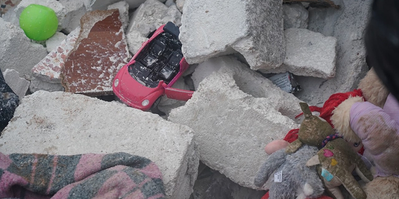 Turkey and Syria, toys buried in the rubble of destroyed buildings after earthquake.