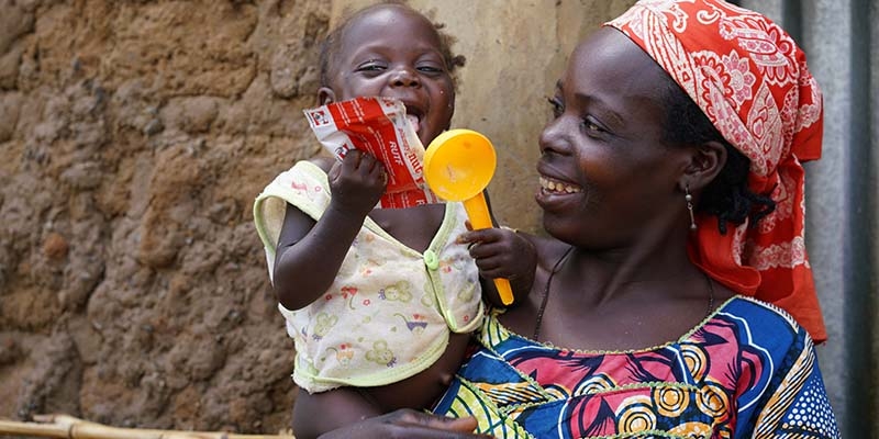 Niger, a mother holds her smiling infant after receiving treatment for malnutrition