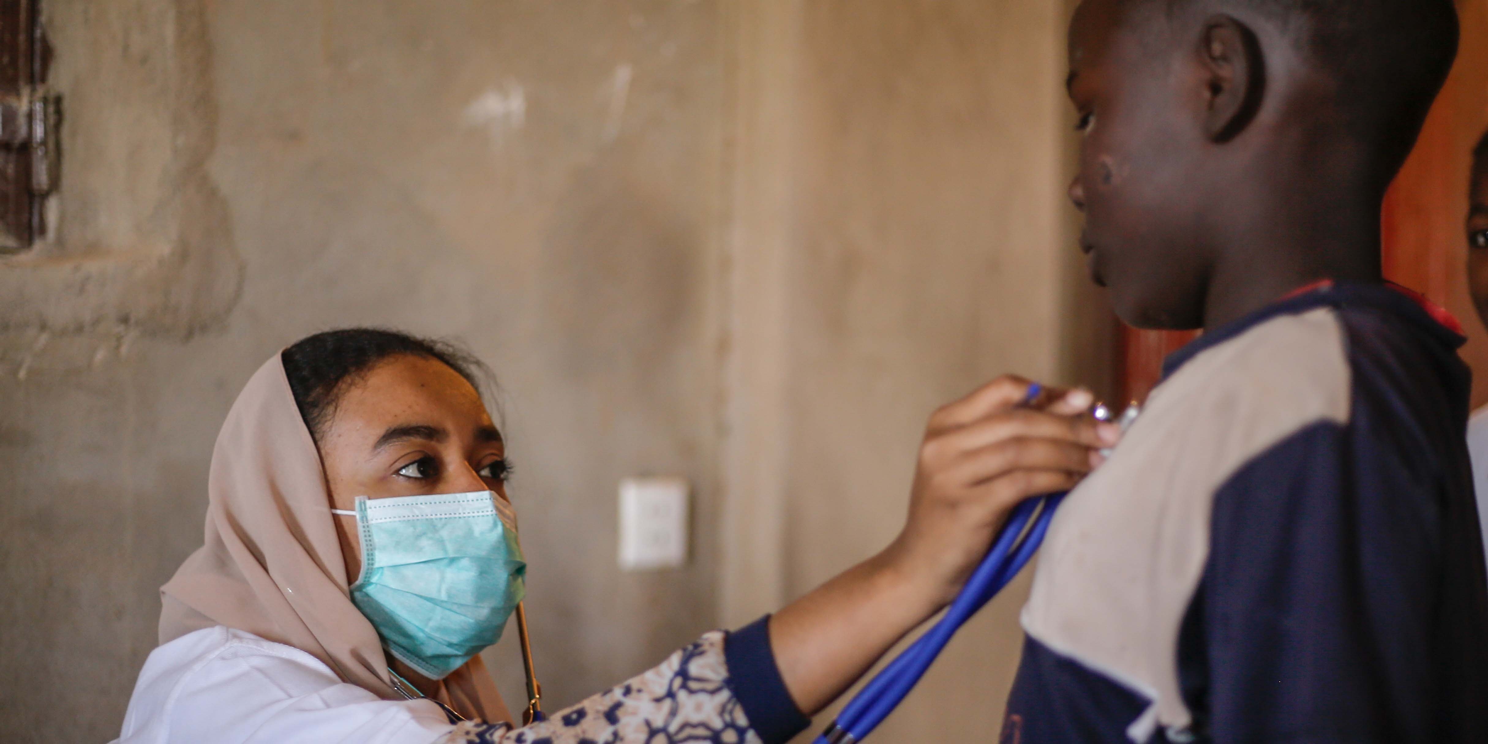 Sudan, a healthcare worker provides treatment to a boy