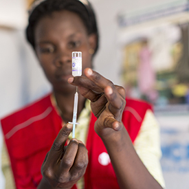 A syringe is prepared for treatment by a medical professional in Uganda.