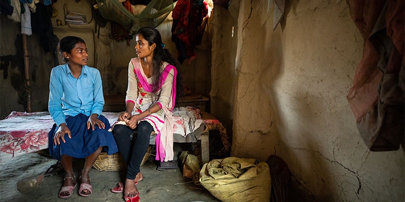 A girl in Nepal speaks with a local aid worker