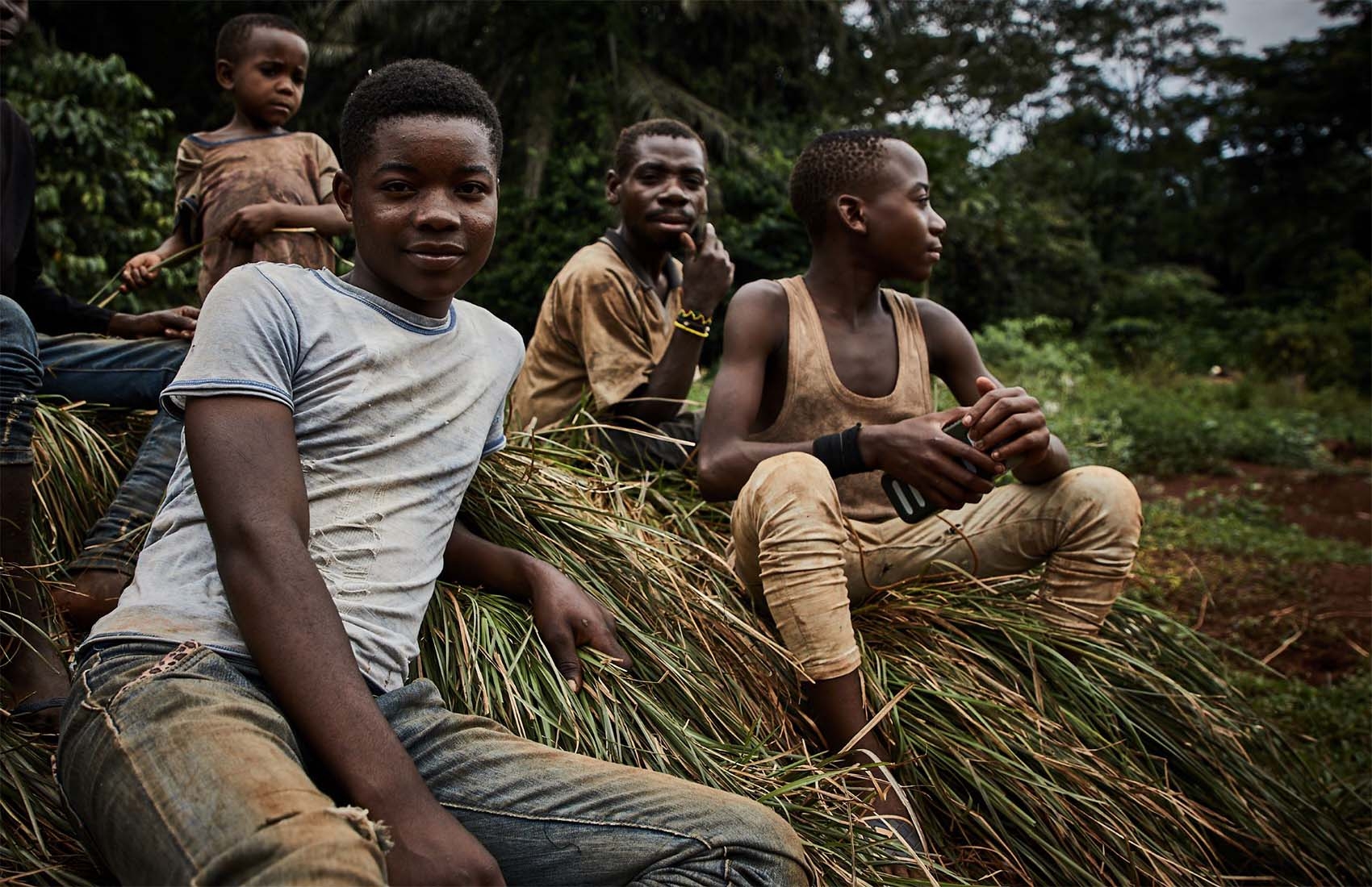 DRC, a group of kids sit together on the side of a hill