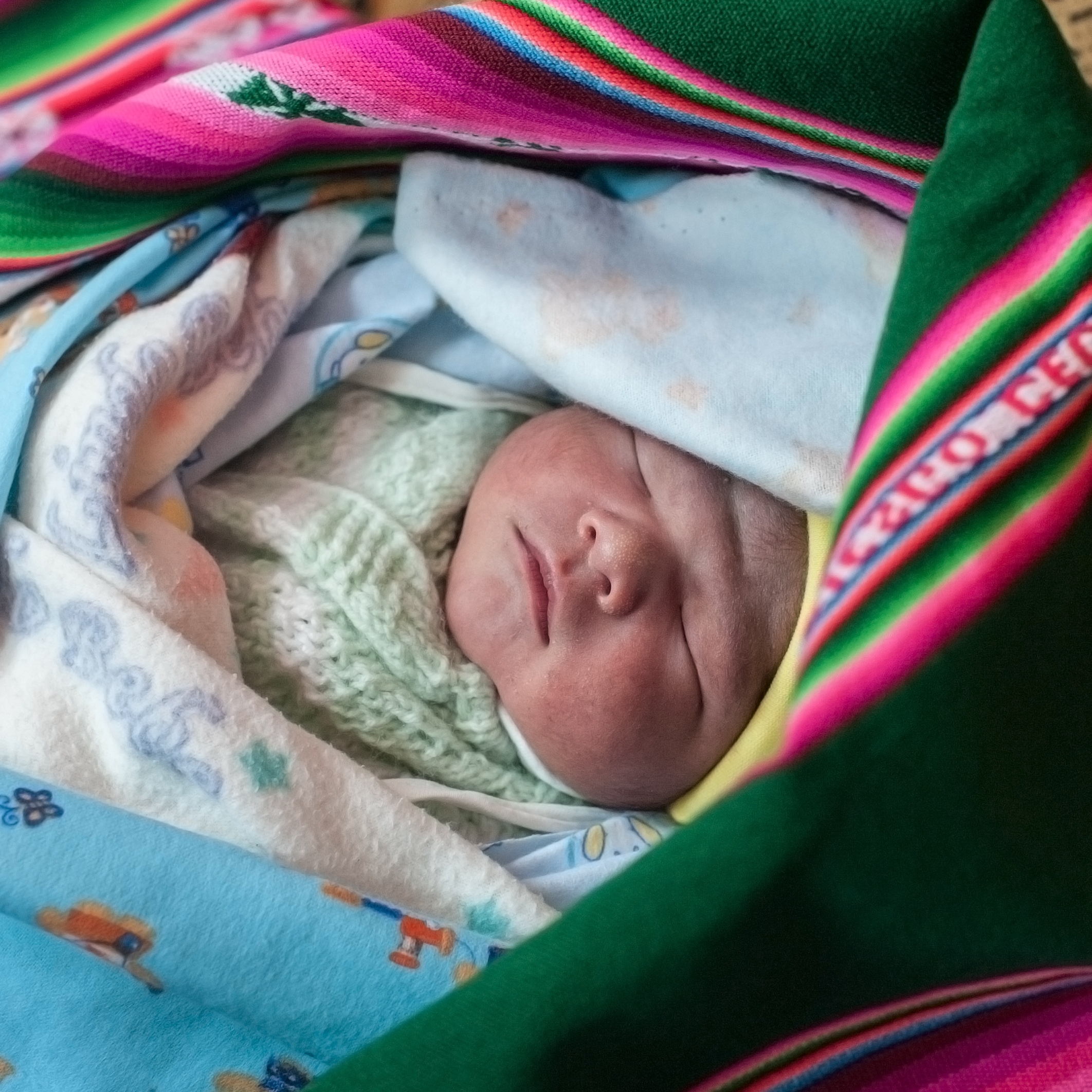 Baby Emanuel, just 1 day old, is healthy and wrapped in a colorful “aguayo” blanket made from llama wool.