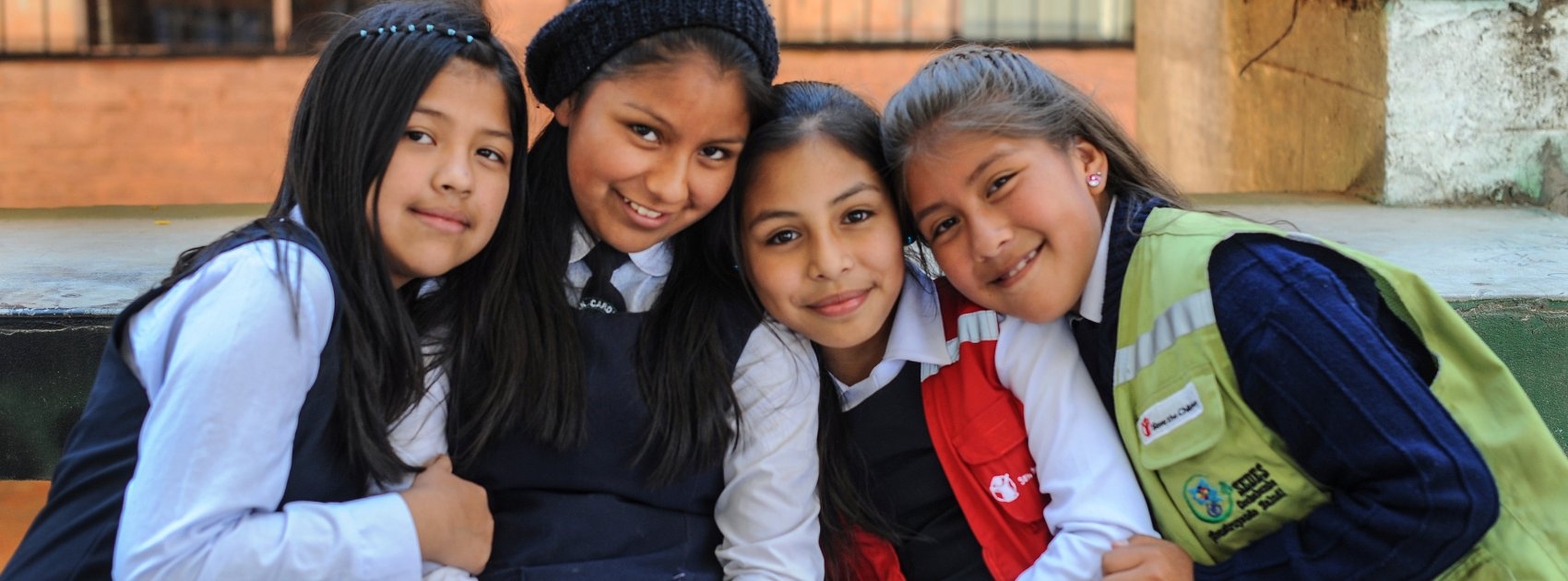 Girls pose for a photograph at a school supported by Save the Children sponsorship programs. Save the Children is working hard in Bolivia to help kids stay healthy and stay in school through sponsorship programs at local elementary schools and early education centers. Photo Credit: Susan Warner/Save the Children 2015.