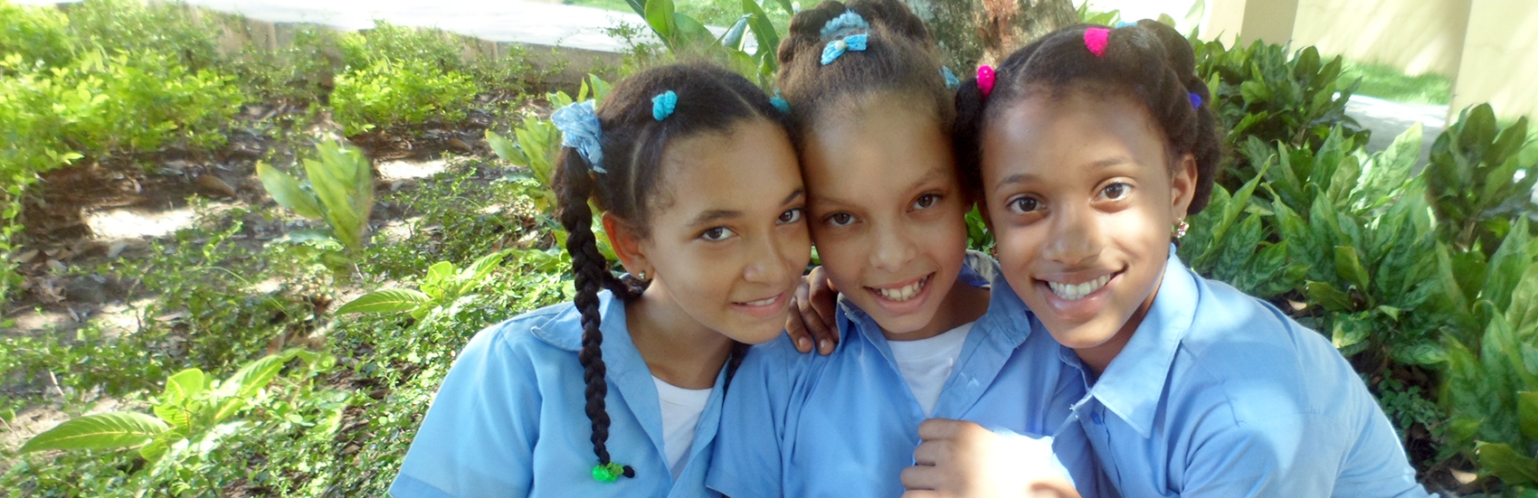 Three school-aged girls attend a Save the Children program at a school in Dajabon, Dominican Republic. Photo credit: Aneliya Nikolova/Save the Children, July 2016.