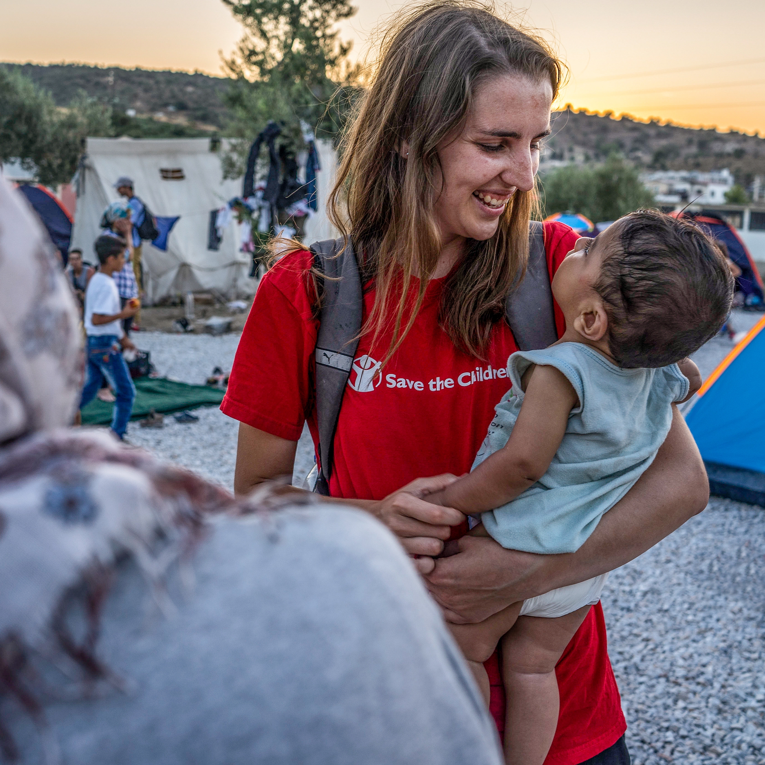 Kate O'Sullivan, communications manager for Save the Children in Greece speaks with a Syrian family from Homs in the informal camp in Kara Tepe, Lesvos. Photo Credit: Anna Pantelia/Save the Children 2015.