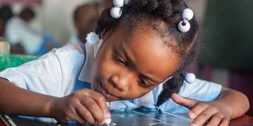 A young student practices letter writing in her preschool classroom in Port au Prince, Haiti. Save the Children worked to help Haiti rebuild its educational system and infrastructure following the destructive and deadly natural disasters. Photo Credit: Susan Warner/Save the Children 2016.