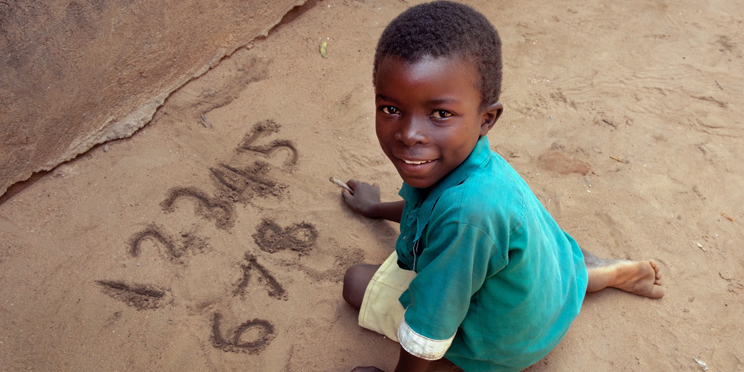 Charles practices writing numbers on the ground at Nanjiri Primary School in Zomba, Soutrhern Malawi