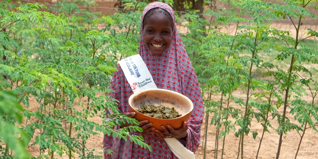 Barira holds a bowl of nutritious moringa grown at her community garden. She leads the fight against child hunger with her local student government. Photo Credit: Talitha Brauer/Save the Children, 2016.