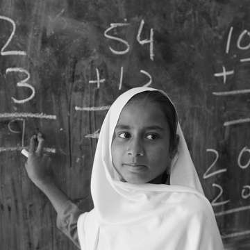 A young student doing math sums on the blackboard in class 3 in a government girls school in Khyber Pakhtunkhwa Province, Pakistan. Photo Credit: Asad Zaidi/Save the Children 2014.