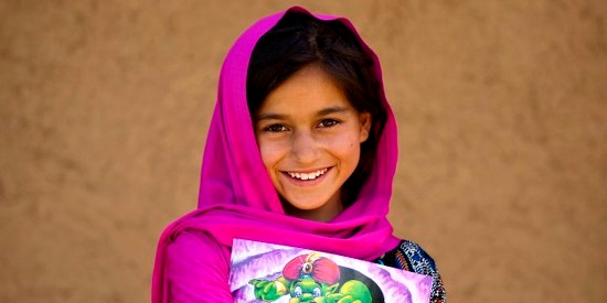A 9 year-old girl with a story book outside her home in her village in Khyber Pakhtunkhwa Province, Pakistan. Photo Credit: Asad Zaidi/Save the Children 2014.