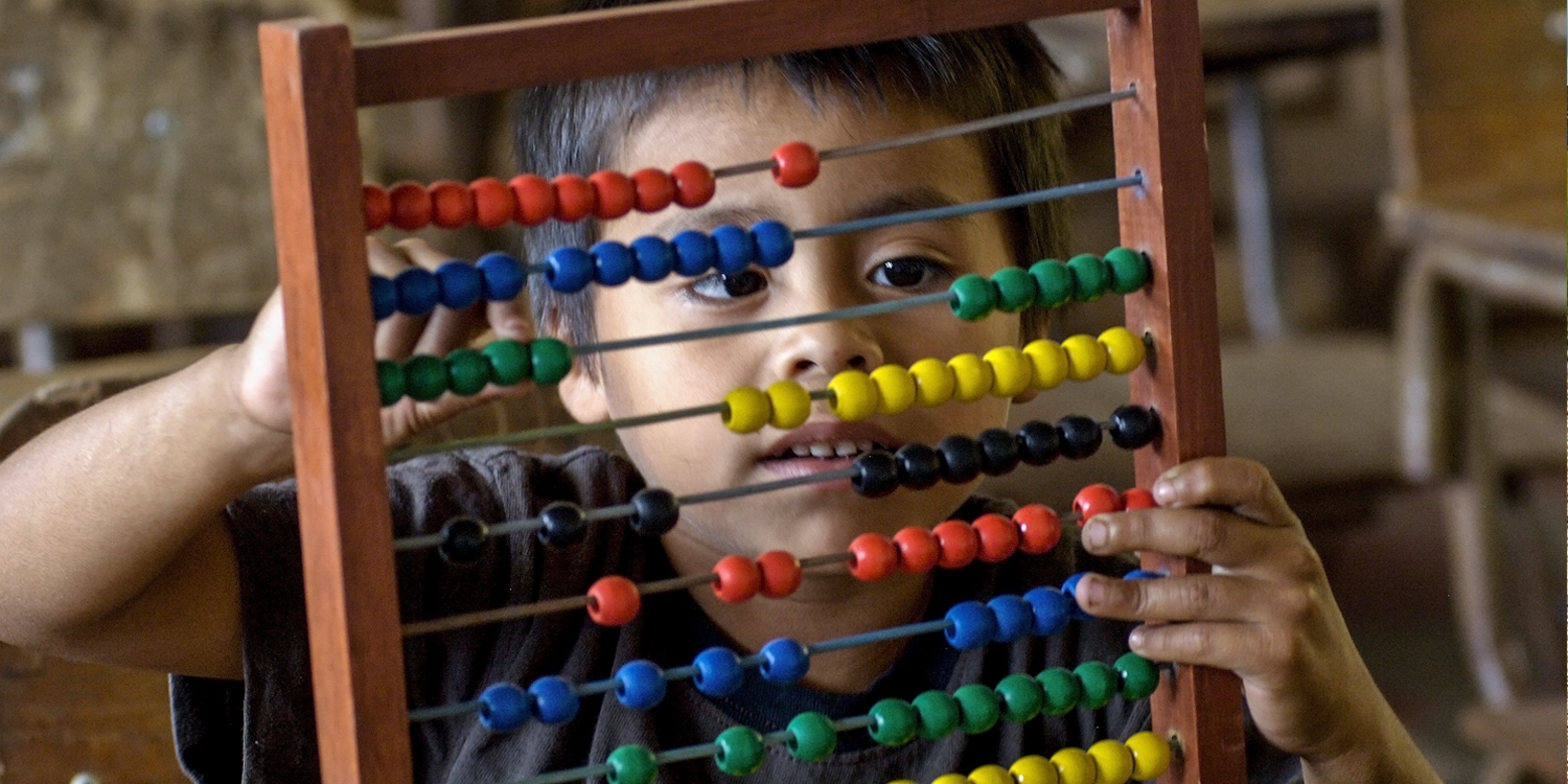 A young boy, age 7, using abacus from Learning Corner Program in his 1st grade class. Photo Credit: Save the Children 2016.