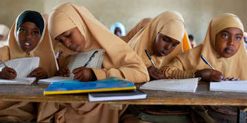 Girls work on school work in a classroom in Somalia.