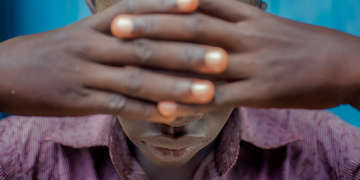 16 year old child in South Sudan covers eyes and has tested positive for HIV and been travelling to a hospital for treatment for several years.