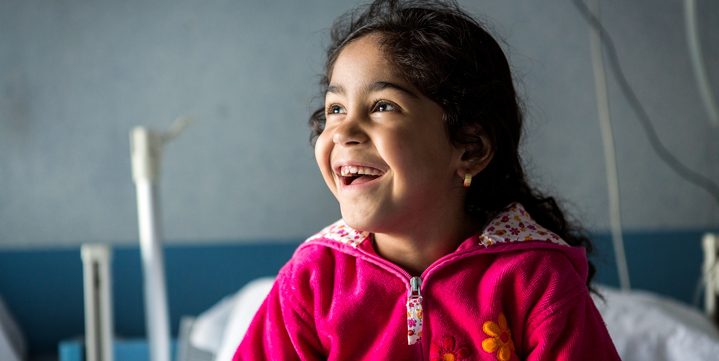 A five-year-old from Syria, plays in her hospital bedroom where she was treated for asthma after being rescued by the Save the Children vessel in the Mediterranean Sea near the coast of Italy. Photo Credit: Louis Leeson/Save the Children 2016.
