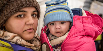 Rabia and her daughter Yasmin take shelter from the snow and freezing temperatures in a tent with their family. Photo credit: Jonathan Hyams/Save the Children, January 2016. 