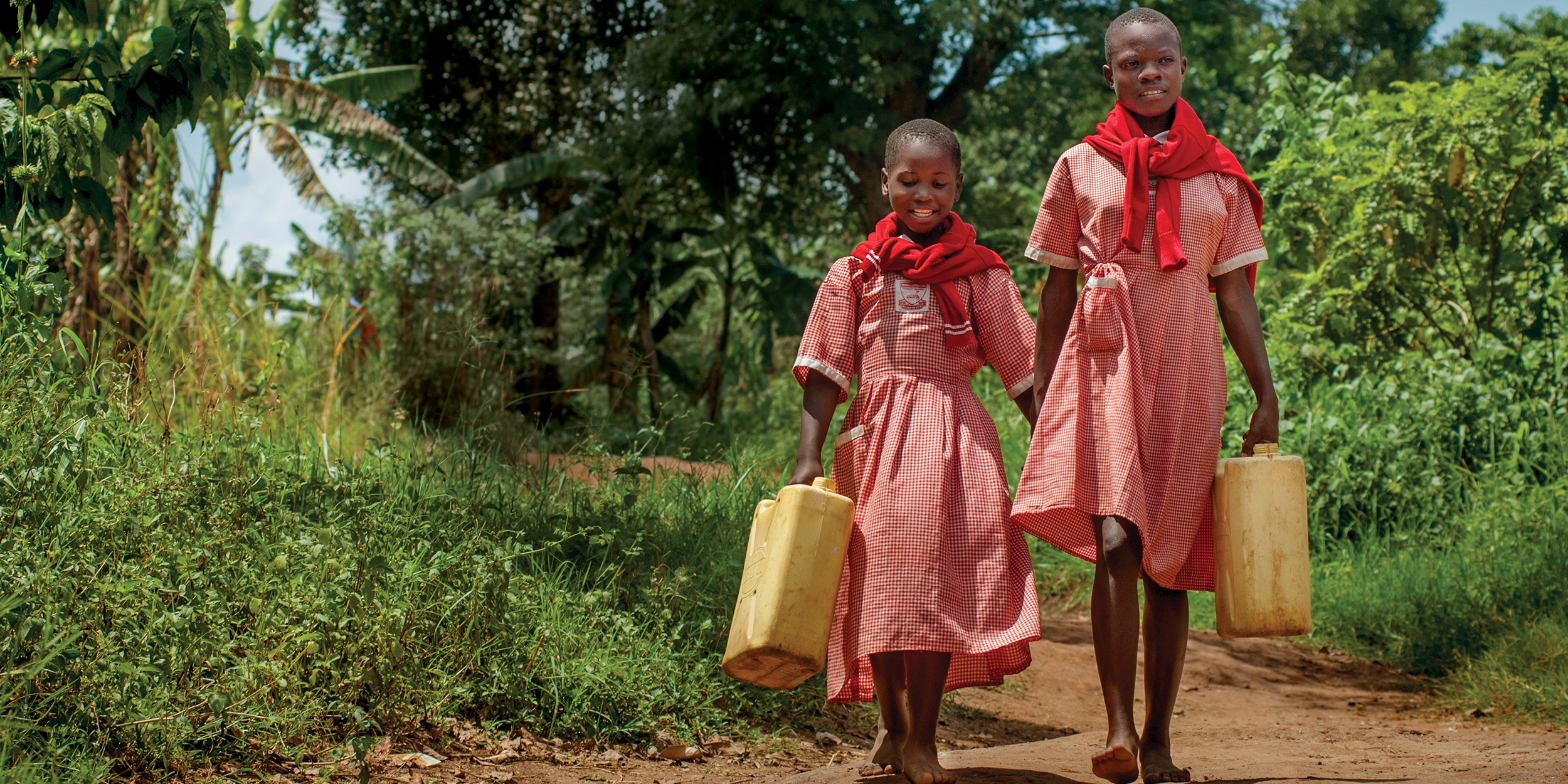 Because of the work of Save the Children, girls like Robina and Charity, ages 9 and 12, can safely fetch the family water – so they can get back to learning in Uganda. Photo credit: Save the Children/Rick D’Elia 2017.