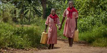 Two young girls fetch water together in Uganda. Photo Credit: Rick D'Elia/Save the Children 2016