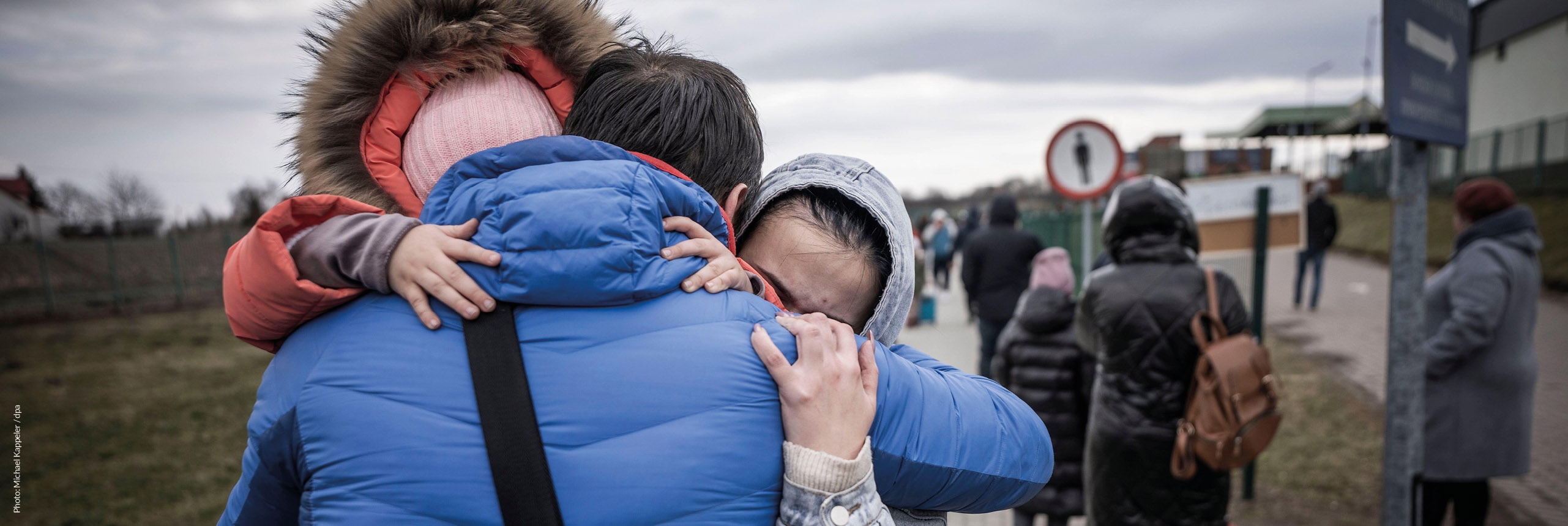 Ukraine, a family hugs each other at a transport depot