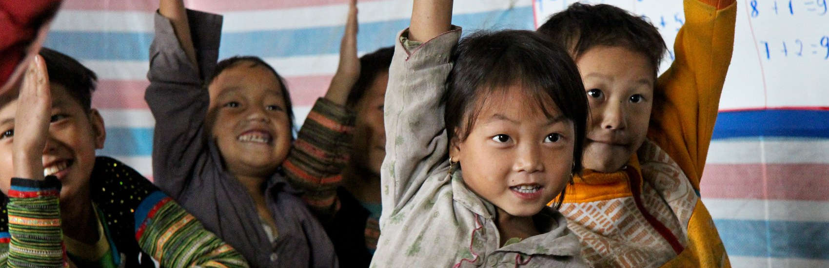 A first grader raises her hand in class, at a primary school in Van Chan, Vietnam. Save the Children supports this school (and others) with our Early Childhood Care and Development project, to address health and educational needs of children under six. Photo credit: Karin Kuhns/Save the Children, February 2013.