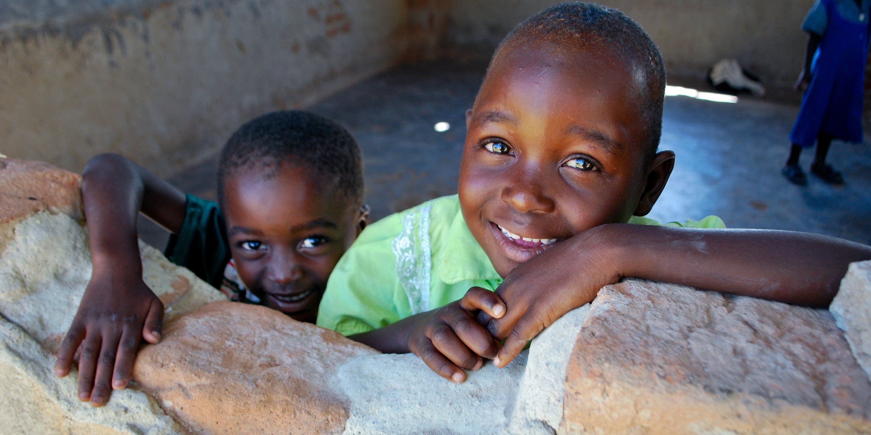 Two children look out the "window" at the Early Childhood Center in a village in Zimbabwe. Photo Credit: Eileen Burke/Save the Children 2011.