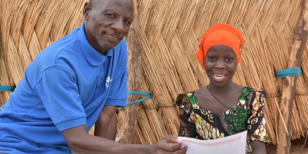 Hamissou reading a letter to Harira, a sponsored child in Niger. Photo credit: Save the Children 2019.
