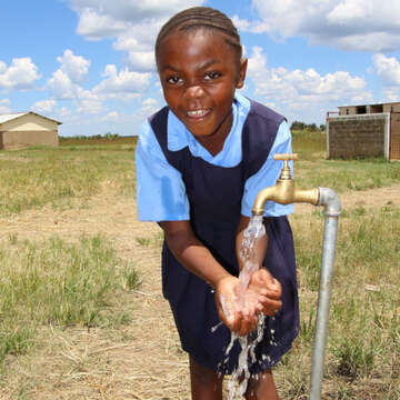 Hannah enjoys clean water. Photo credit: Save the Children 2020.