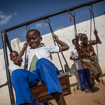 A young boy plays on a swing set. Photo credit: Hedinn Halldorsson / Save the Children.