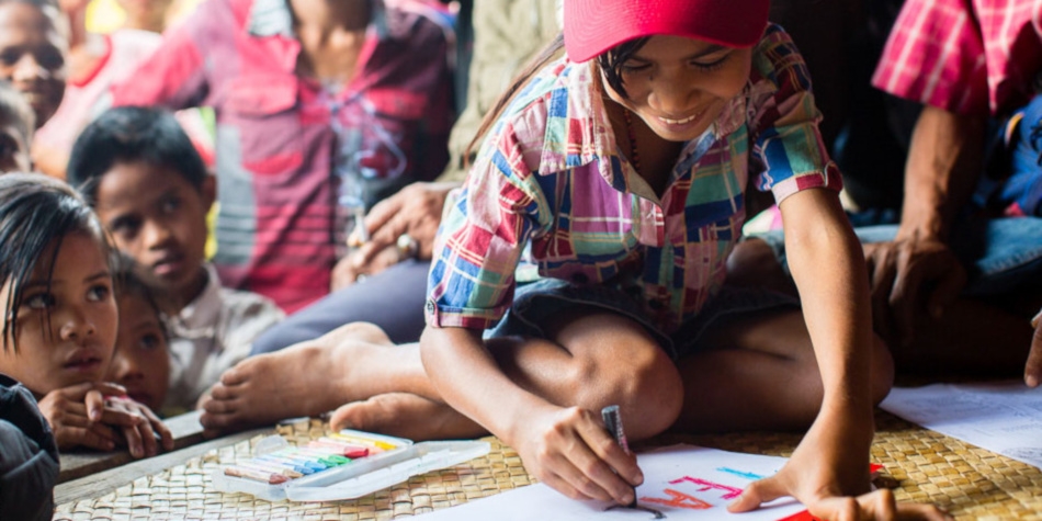 A young sponsored child draws a picture. Photo credit: Save the Children 2018.