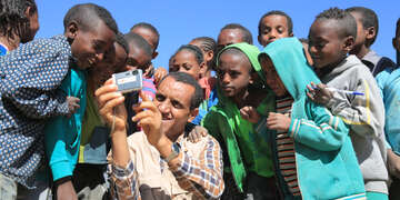 Sponsorship Operations Officer Gebrerufael Gebrehiwot photographing a group of children. 