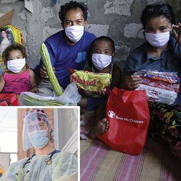 A family wearing facemasks, sits together with supplies for the Coronavirus pandemic from Save the Children.