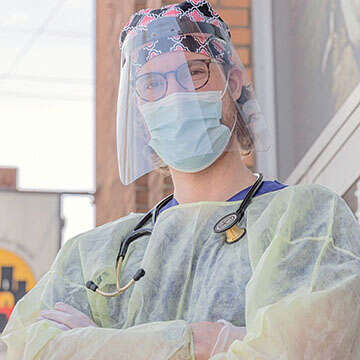 A healthcare worker stands in PPE.