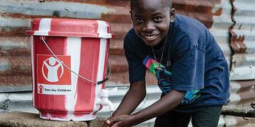 A child washes his hands in a clean water kit