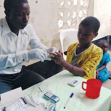 A child recieves malaria treatment from a doctor. 