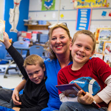 Twins Logan and Lucas, both 7 laugh with their grandma and legal guardian, in their classroom in Kentucky. The brothers are part of Save the Children's in school literacy program that provides training, tools and support schools need to accelerate reading growth for struggling readers. Photo credit: Ellery Lamm / Save the Children 2018. 