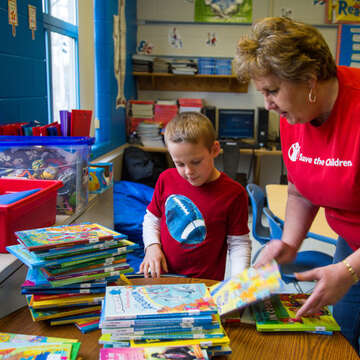 Logan, 7, and Miss Reeder look for books together in their classroom in Kentucky. Logan is part of Save the Children's in school literacy program that provides training, tools and support schools need to accelerate reading growth for struggling readers. Photo credit: Ellery Lamm / Save the Children 2018. 