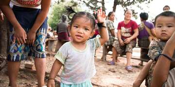 A small girl waves in Laos