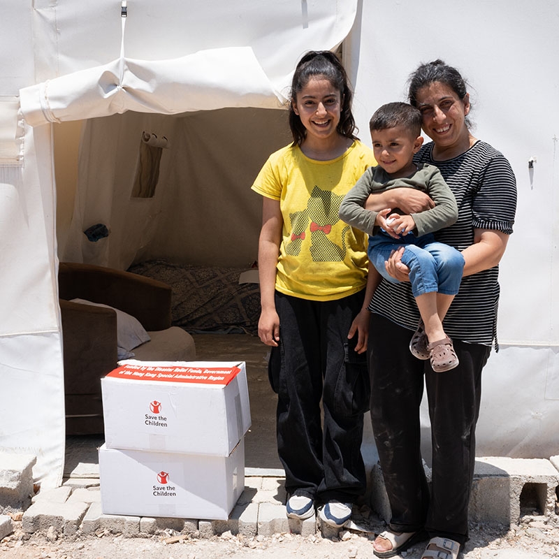 In Turkiye, a family that survived the earthquakes received boxes of essentials outside of their new tent.