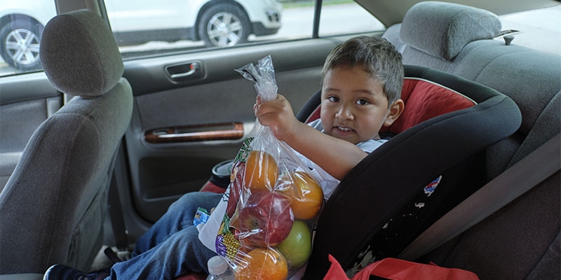A toddler with a large bag of fruit at a SNAP outreach event in Arkansas, U.S.