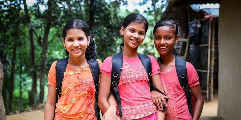 Three girls with school bags