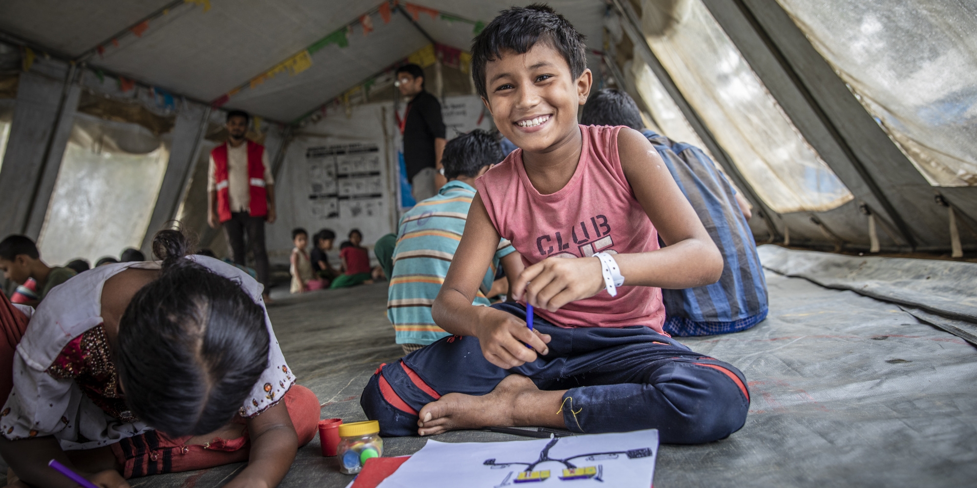 Nur*, 11, takes part in activities at Save the Children’s Child Friendly Space, in a Rohingya refugee camp in Bangladesh. Nur*, who has been deaf since birth, became separated from his parents after their village was attacked in Myanmar. He’s now living with extended family. Nur* receives support from a Save the Children caseworker. Photo Credit: Jonathan Hyams / Save the Children 2018.
