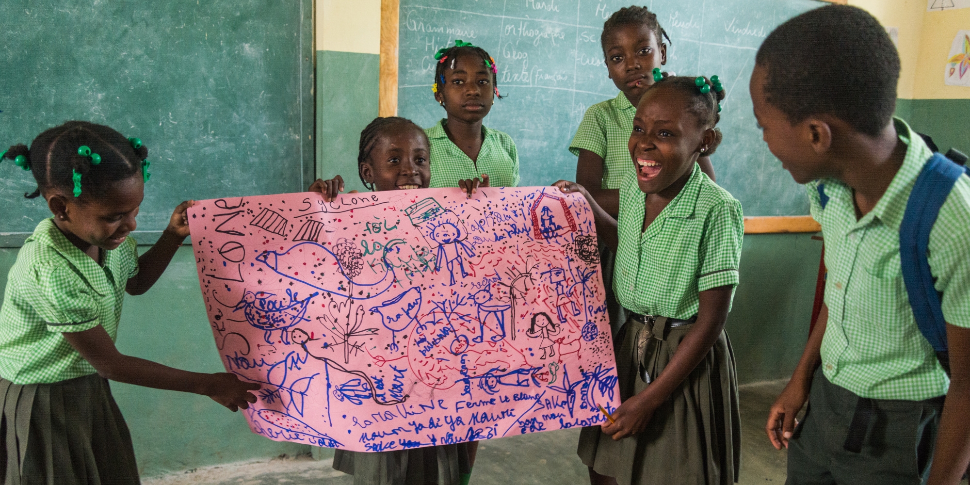 A group of children explain a picture that they drew showing what they experienced during Hurricane Matthew, at the Child Friendly Space at a school. Photo credit: Ray-ginald Louissaint Jr / Save the Children 2018.