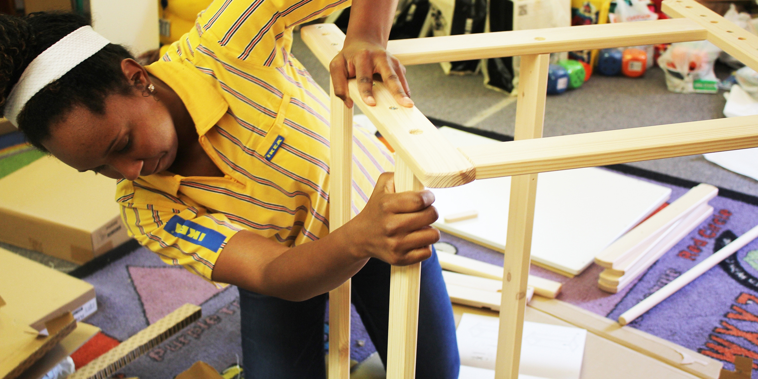 This photo was taken by Laura Gomez, Communications Manager, U.S. Programs, in April 2018. The pictured IKEA iWitness trip participant is assembling furniture as part of a childcare center renovation project. The center was damaged after Hurricane Harvey, and IKEA provided supplies and support to update one of their classrooms, to allow the center to build back to full capacity. Photo credit: Laura Gomez/Save the Children 2018.