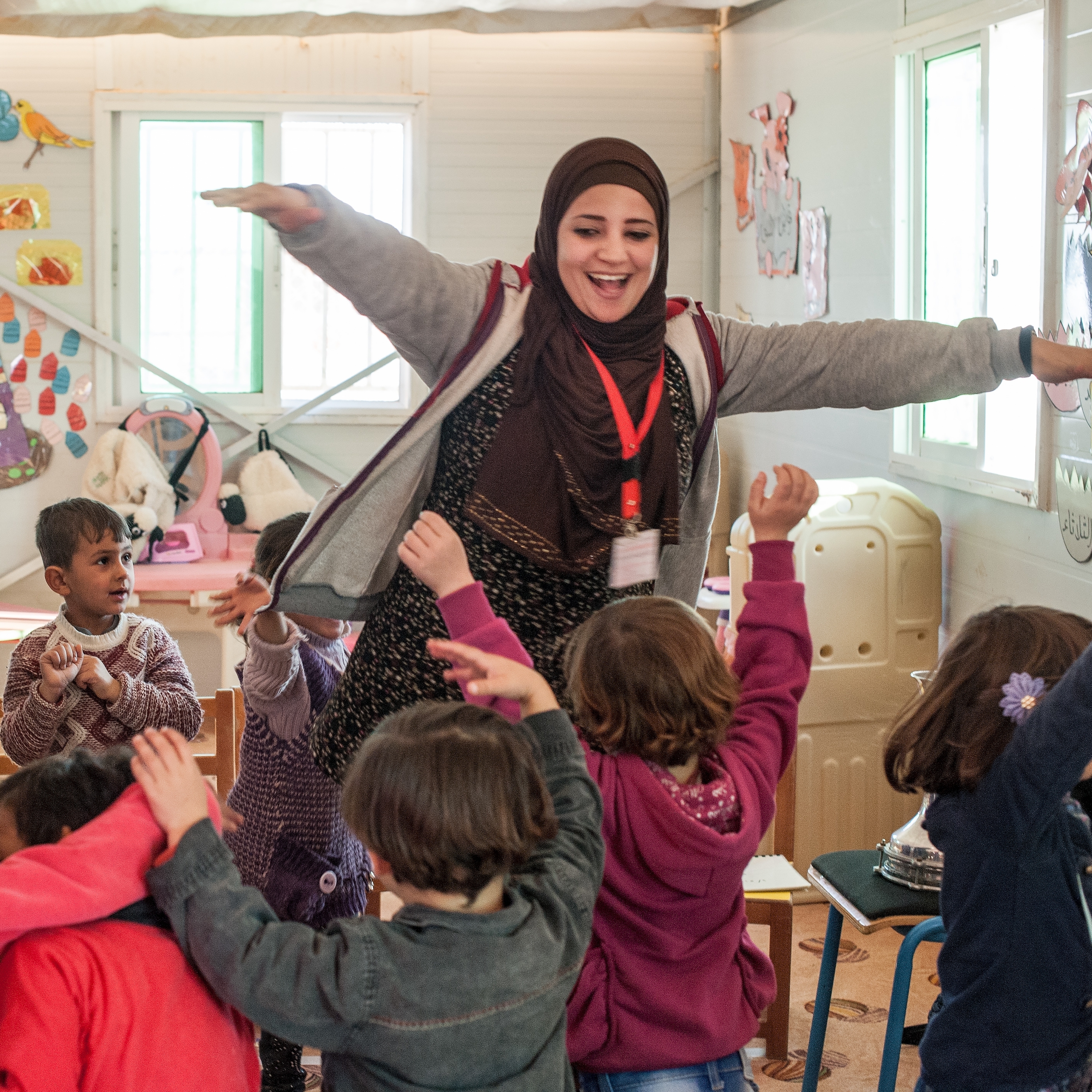 A kindergarten teacher leads her students in a music activity at a Save the Children Rainbow Kindergarten for refugee children. Every classroom runs a Healing and Education Through the Arts (HEART) activity daily. Photo credit: Susan Warner/Save the Children, December 2016.