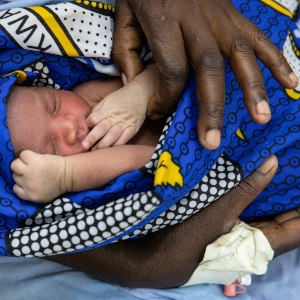A two-day-old baby is wrapped in a brightly colored blanket and held by a health worker at the County Referral Hospital in Kenya. CHX was used on the baby’s ambilitical cord to prevent post-natal infection. Photo credit: Siegfried Modola / Save the Children, Aug 2018.