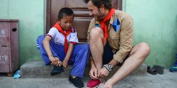 TOMS’ Founder and Chief Shoe Giver, Blake Mycoskie, shares a special moment with a student in a school for migrant children while in Beijing for the company’s annual “One Day Without Shoes” awareness campaign. Photo Credit: TOMS' 2015.